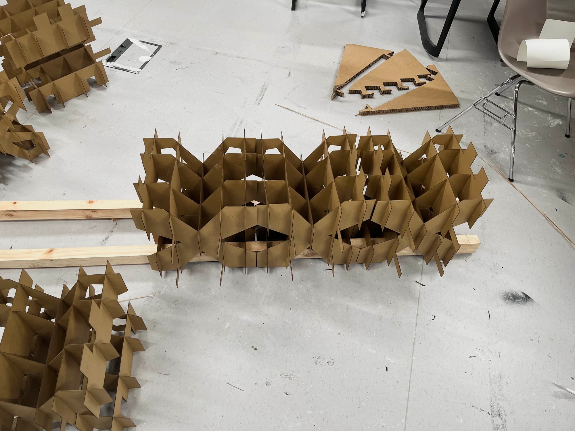 Photograph of two cardboard cubes locking onto wooden base frame.