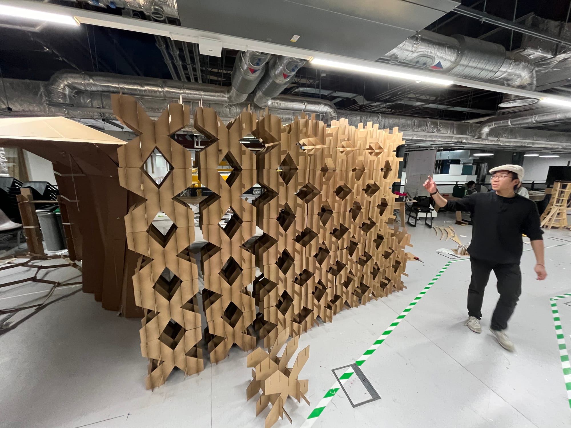 Photograph of Rex next to a complete wall of cardboard cubes.